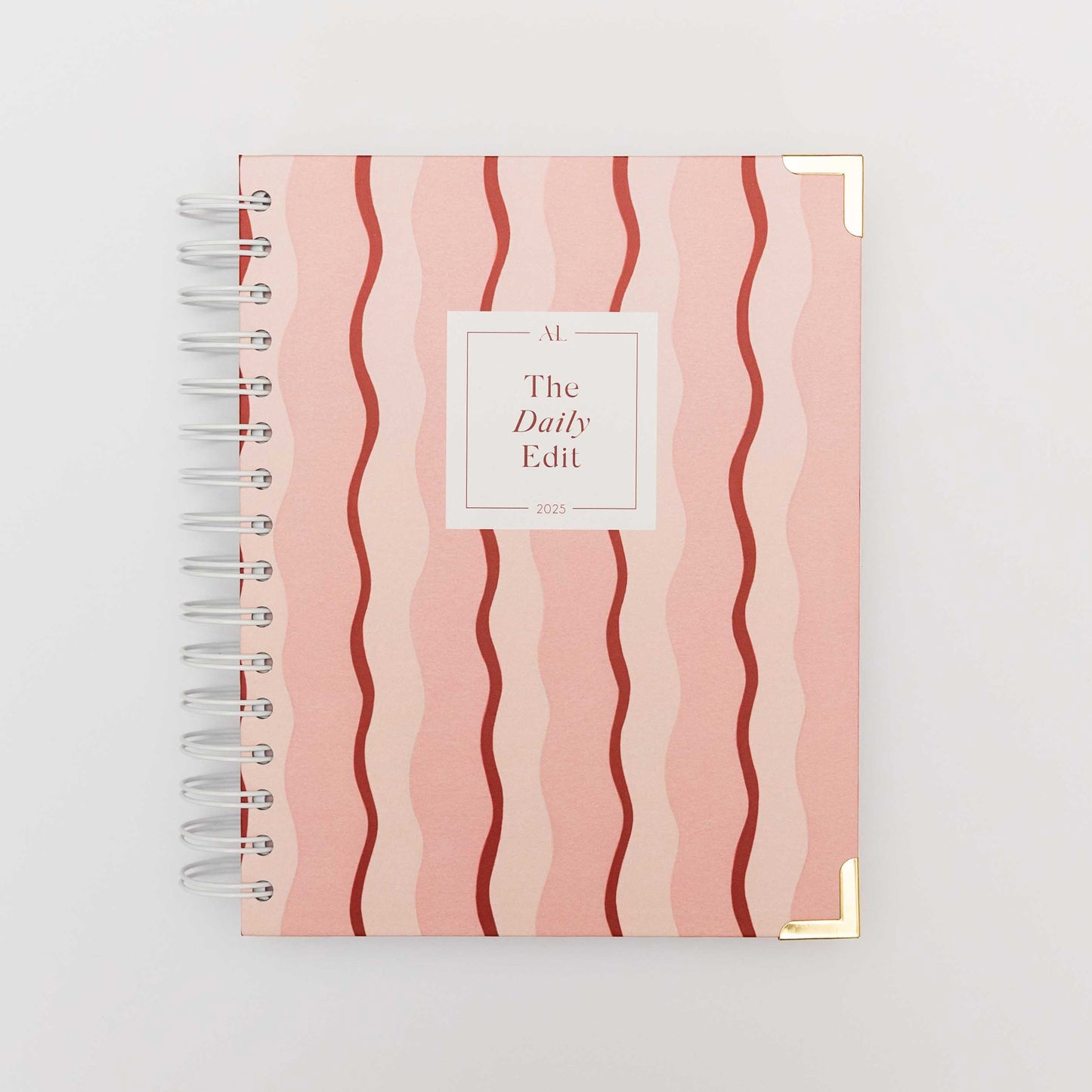 The Daily Edit - 2025 Planner by Alexa Lily with pink wavy stripes and spiral binding